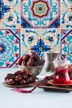 Assorted dried dates or kurma served on a vintage plates and tea. Stock Photos