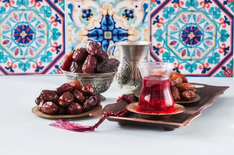 Assorted dried dates or kurma served on a vintage plates and tea. Stock Photos