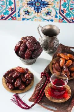 Assorted dried dates or kurma served on a vintage plates and tea. Stock Photos