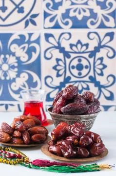 Assorted dried dates or kurma served on a vintage plates and tea. Stock Photos
