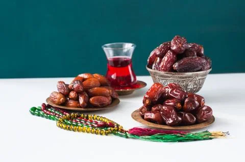 Assorted dried dates or kurma served on a vintage plates and tea. Stock Photos