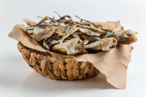 Assorted dried fish in a basket on craft paper Stock Photos