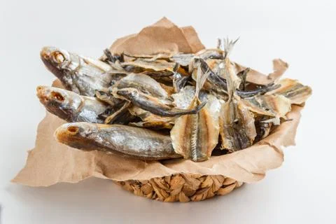 Assorted dried fish in a basket on craft paper Stock Photos
