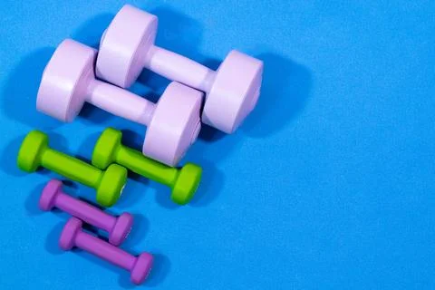 Assorted dumbbells on blue mat Stock Photos