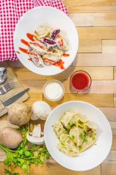 Assorted dumplings, cherry, potato, composition on the table Stock Photos