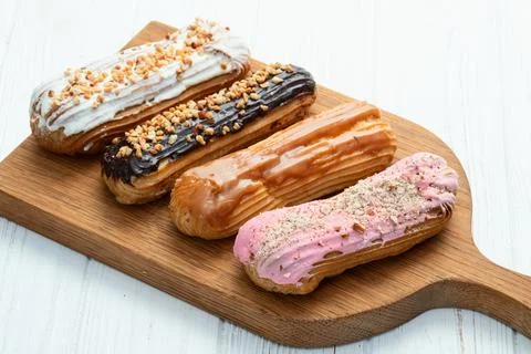 Assorted eclairs on a pastel top view Traditional French dessert Stock Photos