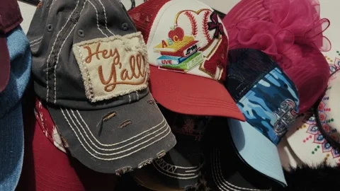 Assorted embroidered caps displayed on wall rack Stock Footage 321285069