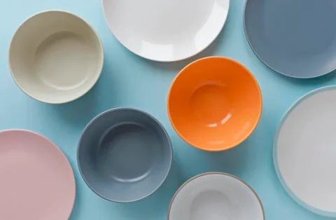 Assorted empty clean bowls and plates on blue Stock Photos