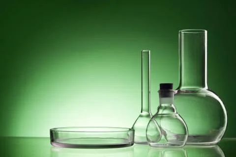 Assorted empty laboratory glassware, test-tubes. Green tone medical background 库存照片