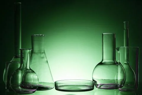 Assorted empty laboratory glassware, test-tubes. Green tone medical background 库存照片