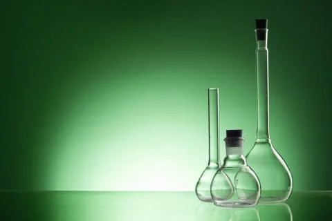 Assorted empty laboratory glassware, test-tubes. Green tone medical background 库存照片