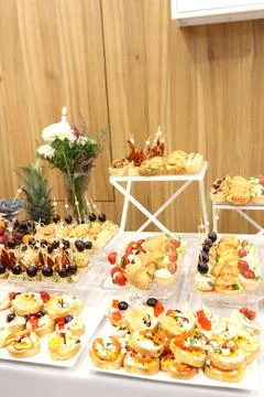 Assorted festive appetizers, canapes and pastries displayed on a buffet table Stock Photos