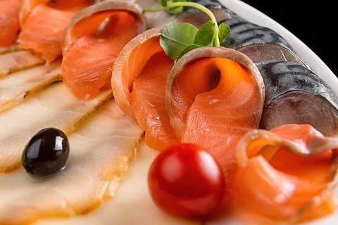 Assorted fish with lemon, olives and cherry tomatoes, close-up Stock Photos