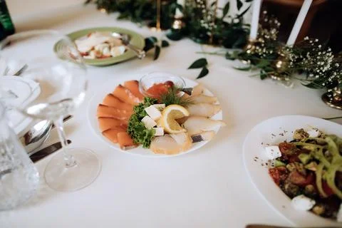Assorted fish on a plate on a holiday table in a restaurant. Different holida Stock Photos