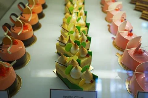 Assorted flavor colorful eclair and French pastry bakery displayed in glass show Foto stock