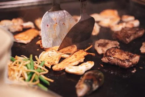 Assorted food being cooked together on a griddle Stock Photos