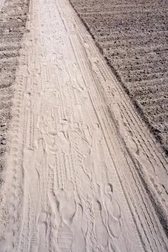 Assorted footprints in dust in a diagonal composition with copy space area Foto stock