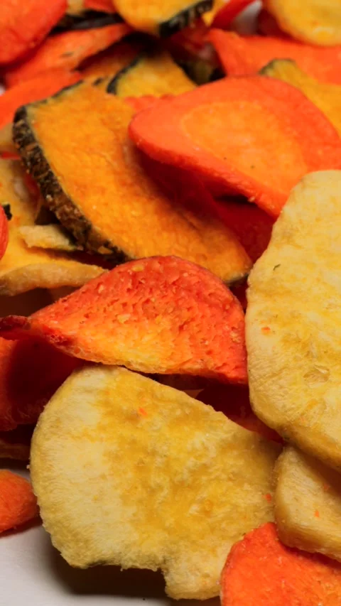 Assorted freeze-dried vegetables rotating in a circle. Mixed slices of zucc.. Stock Footage 318675610