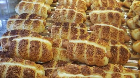 Assorted Fresh Artisan Bread Loaves &amp; Sweet Pastries Displayed in Bakery Case Stock Photos