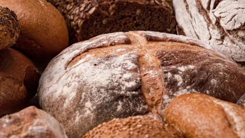 Assorted fresh artisanal bread loaves and rolls displayed on table surface .. 動画素材 337335937