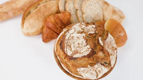 Assorted Fresh Baked Artisanal Breads and Pastries on White Background Stock Footage 338053462