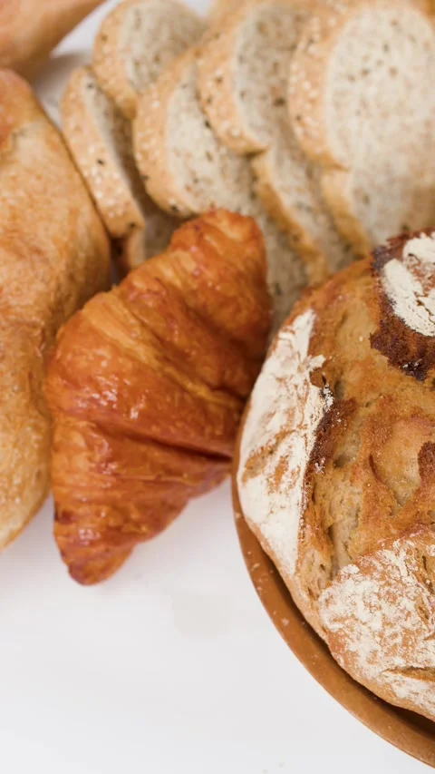 Assorted Fresh Baked Artisanal Breads and Pastries on White Background Stock Footage 338054689