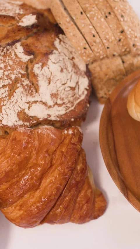 Assorted Fresh Bakery Bread and Pastries on Wooden Plate Stock Footage 337746919