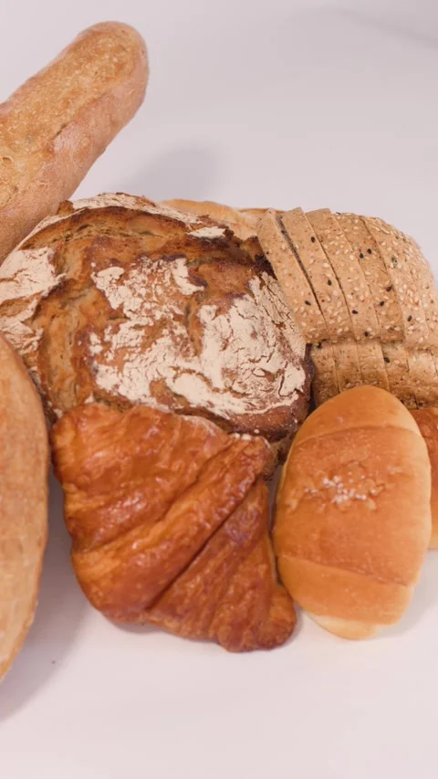 Assorted Fresh Bakery Bread and Pastries on White Background Stock Footage 338052142