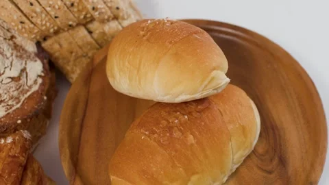 Assorted Fresh Bakery Bread and Rolls on Wooden Plate Stock Footage 339125986