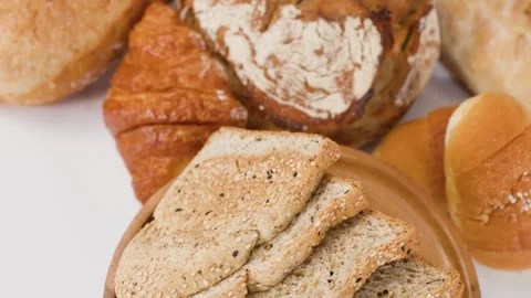 Assorted Fresh Bakery Breads and Sliced Whole Grain Toast on Wooden Plate Stock Footage 337917752