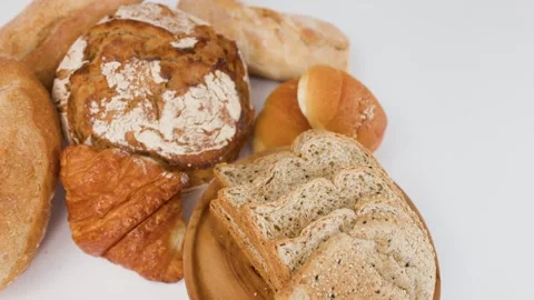 Assorted Fresh Bakery Breads and Pastries on White Background Stock Footage 337917842