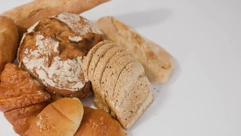 Assorted Fresh Bakery Breads and Pastries on White Background Stock Footage 337995344