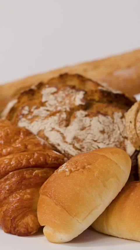 Assorted Fresh Bakery Breads and Pastries on White Background Stock Footage 337998010