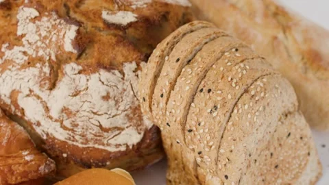 Assorted Fresh Bakery Breads and Pastries on White Background Stock Footage 338054957