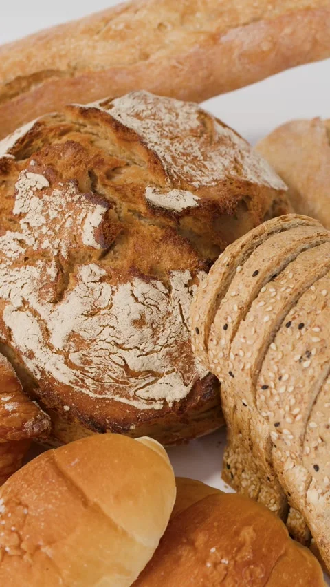 Assorted Fresh Bakery Breads and Pastries on White Background Stock Footage 338321324