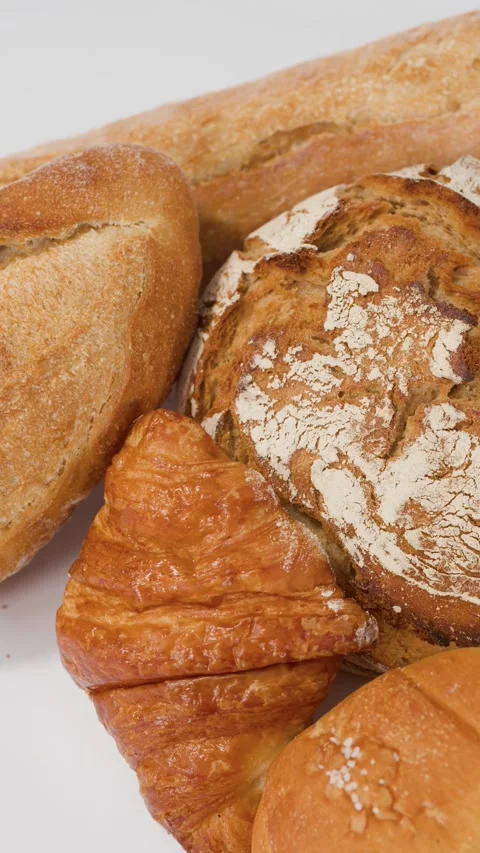 Assorted Fresh Bakery Breads and Pastries on White Background Stock Footage 338374891