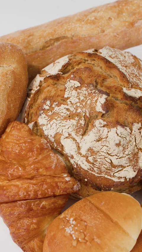Assorted Fresh Bakery Breads and Pastries on White Background Stock Footage 338421100