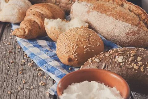 Assorted fresh bread rolls and baguettes on a rustic table Stock Photos