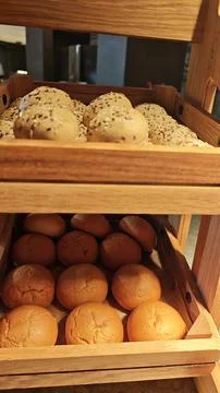 Assorted Fresh Bread Rolls on Rustic Wooden Bakery Shelves Display Stock Photos