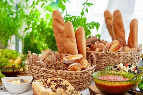 Assorted Fresh Breads and Dips Displayed on a Rustic Table Setting Stock Photos