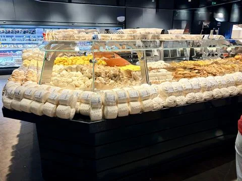 Assorted Fresh Cheeses Displayed in a Modern Supermarket Counter Stock Photos