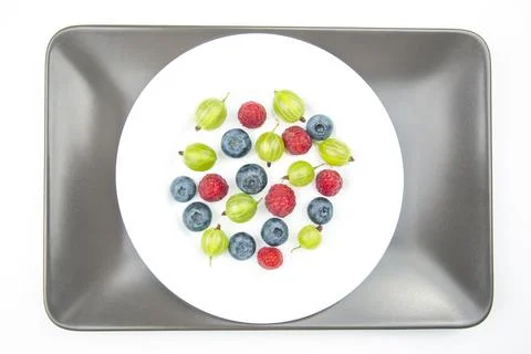 Assorted fresh different berries on a white plate. useful vitamin healthy foo Stock Photos