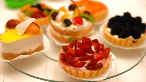 Assorted fresh fruit pastries spinning on glass Video stock 94090894
