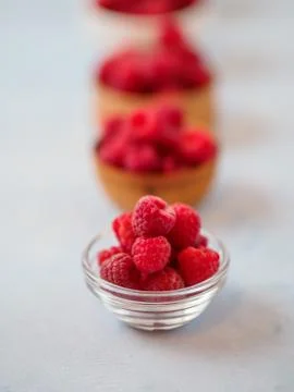 Assorted fresh raspberry in different plates. Stock Photos