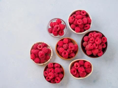 Assorted fresh raspberry in different plates. Stock Photos