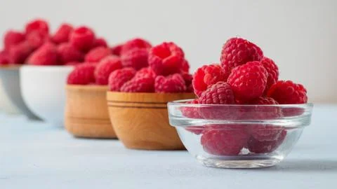 Assorted fresh raspberry in different plates. Stock Photos