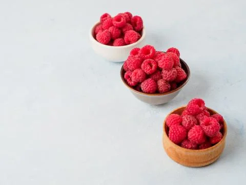 Assorted fresh raspberry in different plates. Stock Photos