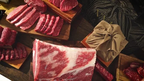 Assorted Fresh Raw Meat Cuts Displayed on Table in Slow Motion 動画素材 335257004