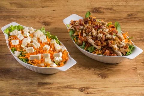 Assorted fresh salads on wooden background Stock Photos