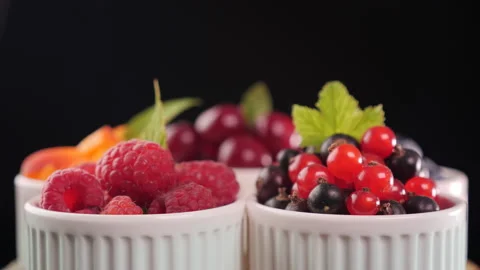 Assorted fresh summer fruits in small cups - rotate on dark background 動画素材 175288706